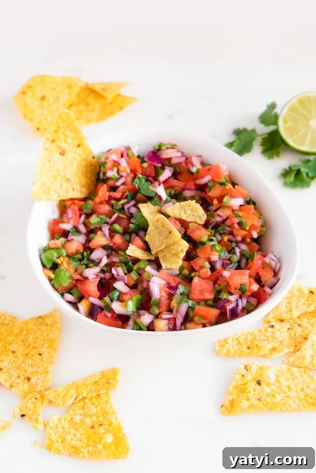 Photo of a bowl of pico de gallo with some tortilla chips