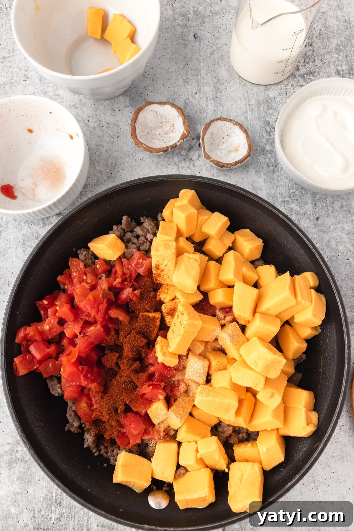 Creamy Velveeta Sausage Dip Recipe for Parties and Game Day 6 Velveeta Sausage Cheese Dip ingredients shown together in a skillet, cubed cheese, rotel and sausage