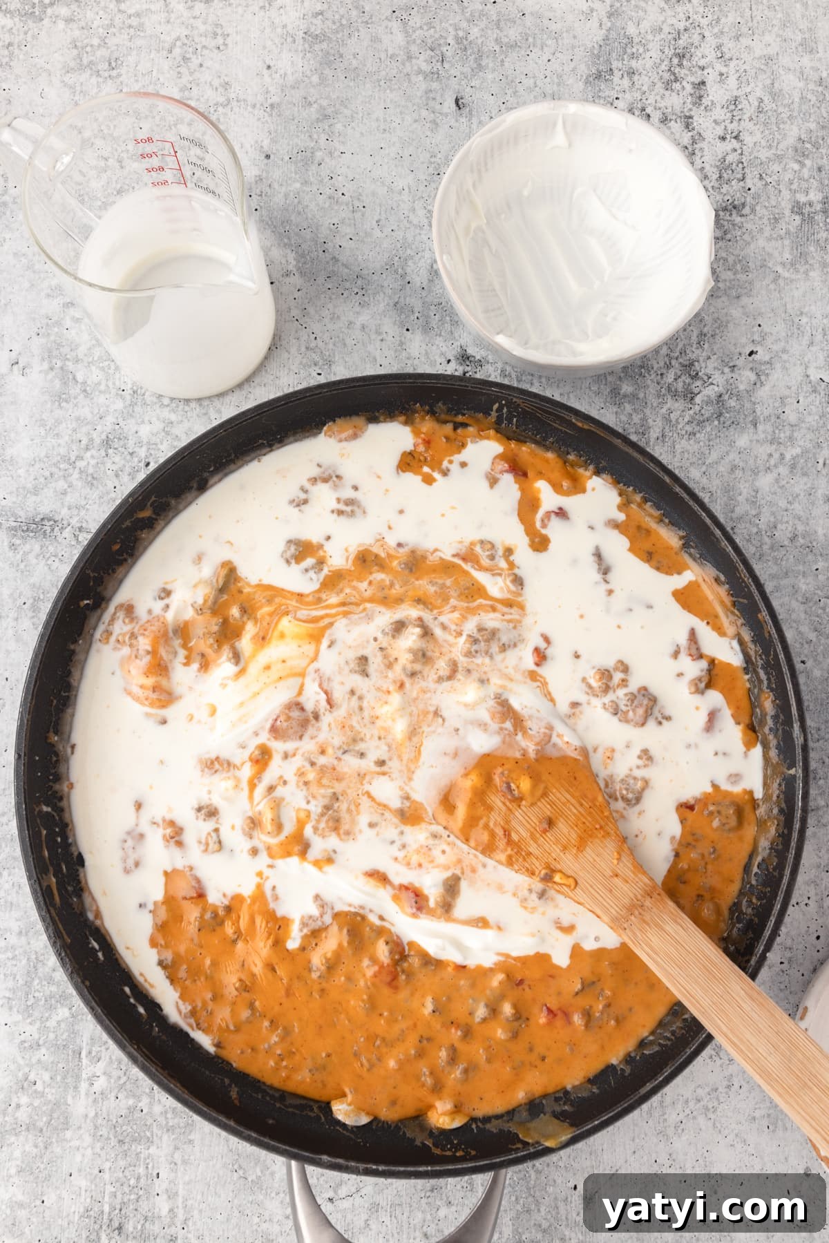 Creamy Velveeta Sausage Dip Recipe for Parties and Game Day 8 Mixing all the ingredients with a large wooden spoon for Velveeta cheese dip.
