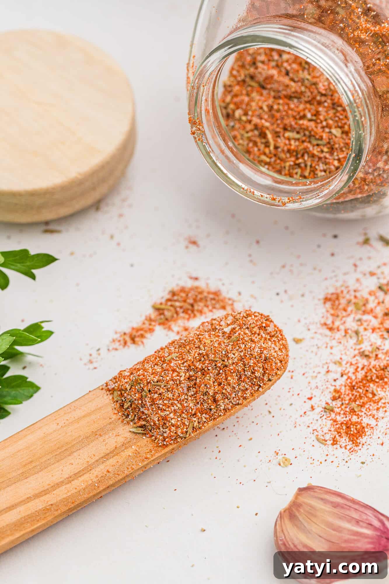 How to Use Cajun Seasoning: Flavor Tips, Recipes & Pairings 2 Cajun seasoning on a small wooden spoon and spilling out of a jar.