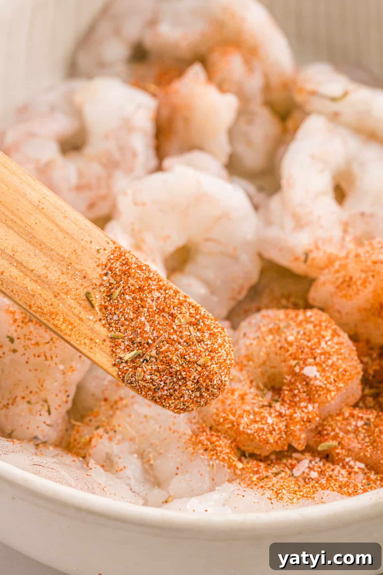 How to Use Cajun Seasoning: Flavor Tips, Recipes & Pairings 9 Cajun seasoning being added to shrimp.