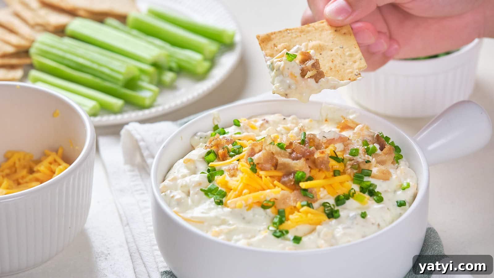 21 Snack Swaps That Beat Junk Food Without Sacrificing Flavor 5 Bacon cheddar dip with shredded cheddar cheese, bacon bits, and chive garnish.