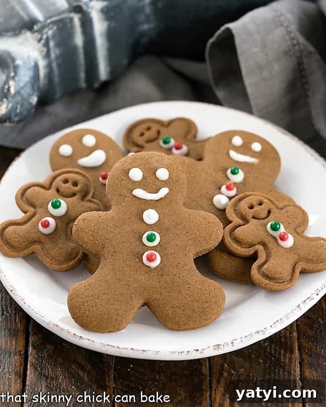 Classic Homemade Gingerbread Recipe: Perfect for Holiday Baking 5 Different sized gingerbread man cookies on a round white plate.