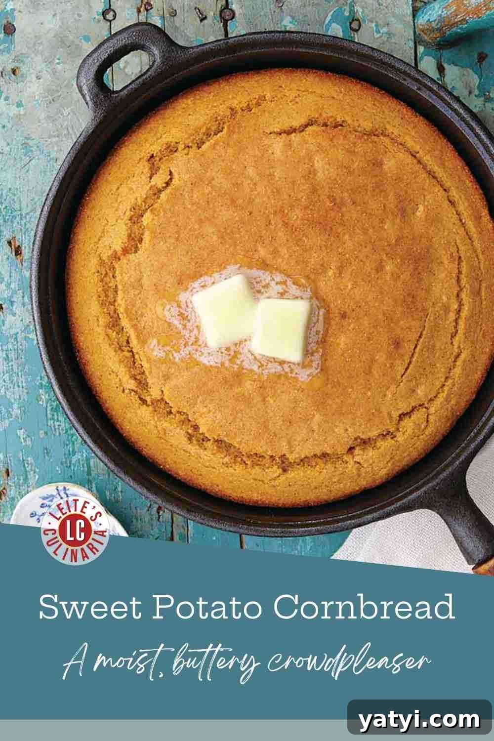 Sweet Potato Cornbread Recipe with Maple Butter Glaze 3 A skillet of moist, orange-hued sweet potato cornbread on a blue wooden cutting board.