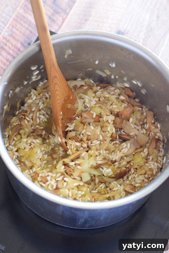 Creamy Mushroom and Leek Risotto Recipe for Cozy Dinners 11 Adding white wine to risotto in a saucepan.
