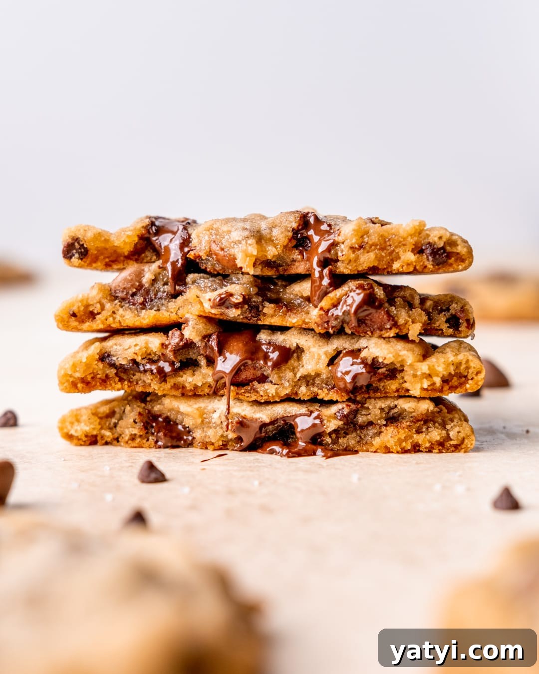 Ultimate Chewy Chocolate Chip Cookie Recipe 8 A stack of chocolate chip cookies cut in half showing their melted chocolate centers.