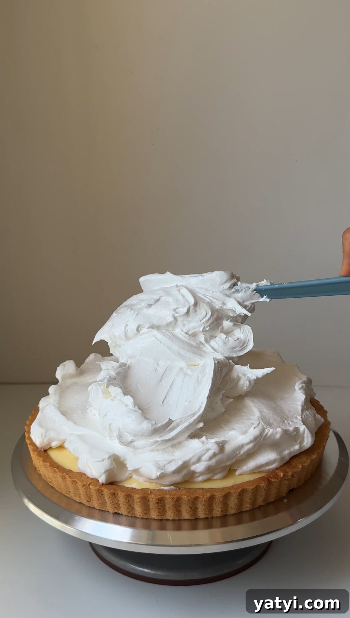 Lemon Meringue Tart Recipe with Crispy Crust and Fluffy Meringue 14 adding meringue on top of tart