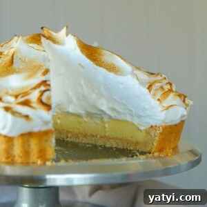 Lemon Meringue Tart Recipe with Crispy Crust and Fluffy Meringue 20 lemon meringue tart with slice removed.